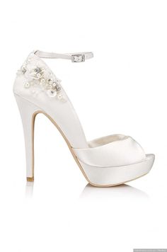 a white high heeled shoe with pearls