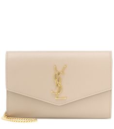 Suited for day-to-night styles, this beige Uptown clutch from Saint Laurent will lend any look a touch of Parisian glamour. It's crafted in Italy from grained calf leather and works an envelope silhouette with the monogram logo in glossy golden hardware. Carry yours in-hand or swing it from the adjustable shoulder strap. | Saint Laurent Uptown Small leather clutch Parisian Glamour, Prom Clutch, Beige Handbags, Leggings Outfit, Best Wallet, Fashion Night, Saint Laurent Bag, Monogram Logo, Leather Chain