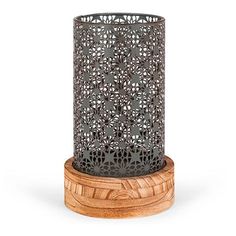 a wooden stand with a metal candle holder on it's top and an intricate design