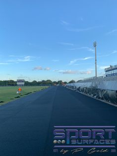 an empty baseball field with the words sport surfaces on it's side and a man standing in the distance