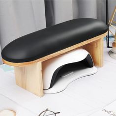 a black and white bench sitting on top of a table next to eyeglasses