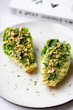 two pieces of food on a white plate with sprinkles and seasoning