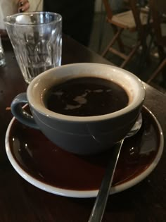 a cup of coffee sitting on top of a saucer next to a glass filled with liquid