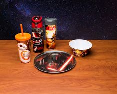 star wars items are sitting on a wooden table with space in the backgroud