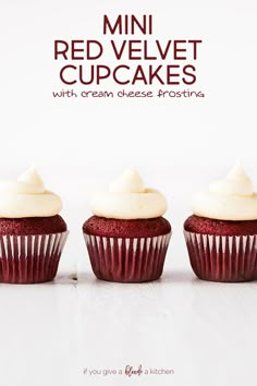 three red velvet cupcakes with cream cheese frosting in front of a white background