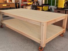 a wooden table with wheels on it in a room full of drawers and other furniture