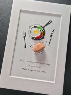 a card with an egg and some sort of biscuit on it, next to a fork and knife