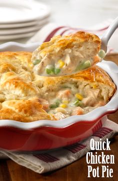 a close up of a casserole dish with chicken and vegetables being lifted by a spoon