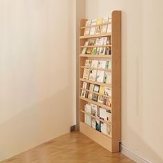 there is a book shelf with many books on it in the corner by the wall