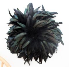 a large black and green feather on top of a chair