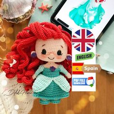 a crocheted little mermaid doll next to a cell phone