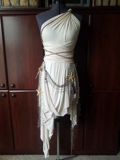 a mannequin wearing a white dress with chains on it