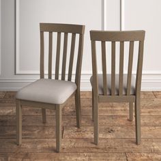 two wooden chairs sitting side by side on top of a hard wood floor next to a white wall