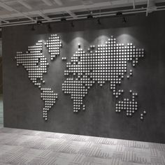 a large metal world map mounted to the side of a wall