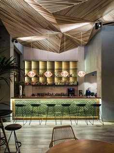 the interior of a modern bar with wooden ceiling