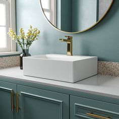 a bathroom sink sitting under a round mirror next to a window with flowers in it