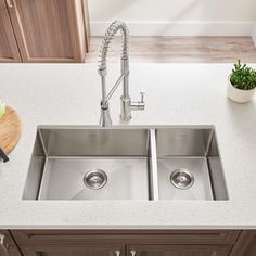 a stainless steel kitchen sink with faucet and soap dispenser on the counter