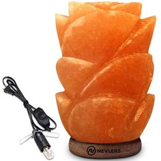 an orange stone sculpture sitting on top of a wooden stand next to a charger