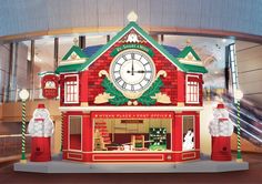 a large clock on the side of a building with christmas decorations in front of it