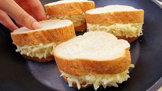 someone is picking up some food from a plate on the table, including bread and cabbage