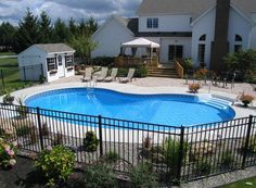 an above ground pool surrounded by a fenced in area with chairs and umbrellas