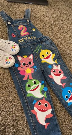 a pair of children's shoes and overalls laying on the floor