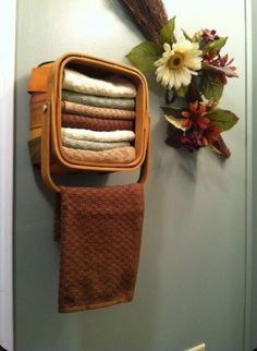 a towel rack with towels hanging from it's sides next to a flower arrangement