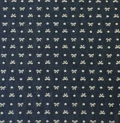 a blue and white fabric with small bows on it