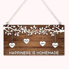 a wooden sign that says happiness is homemade with hearts hanging from the branches and leaves