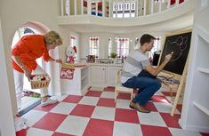 a man and woman in a room with checkered flooring on the floor, one drawing something on a blackboard