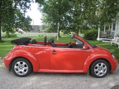 a red convertible car parked in front of a house