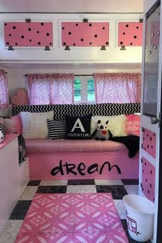 a pink and black room with polka dots on the walls, windows, and rugs