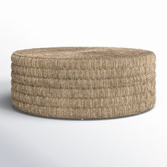 a round ottoman made out of jute and woven material, on a white background