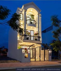 a tall white building with balconies and lights on it's windows at night