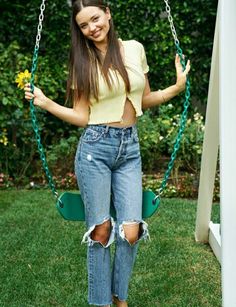 a young woman is sitting on a swing