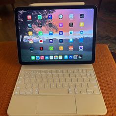 an open laptop computer sitting on top of a wooden table