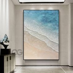 an abstract painting hangs on the wall in a room with white walls and flooring