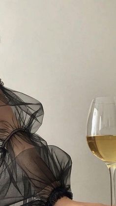 a woman holding a glass of white wine