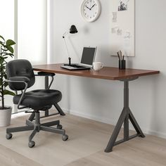 an office desk with a laptop computer on it and a chair in front of it