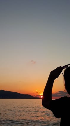 a woman standing on top of a beach next to the ocean