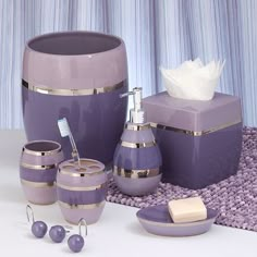 purple bathroom accessories including soap dispenser, toothbrush holder and other items