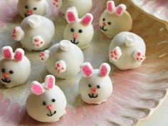 there are many white chocolates with pink bows on them in the shape of bunnies