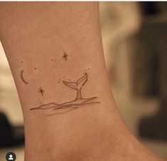 a small tattoo on the ankle of a woman's foot with a whale tail