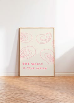 a pink and white poster sitting on top of a hard wood floor