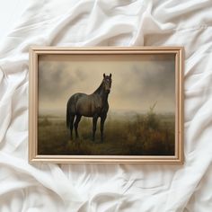 a painting of a horse is hanging on the wall next to a white bed sheet