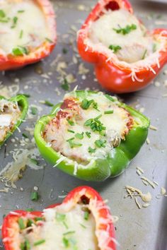 several stuffed peppers with cheese and herbs on a baking sheet, ready to be cooked