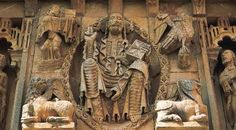 an intricately carved sculpture on the side of a building with statues and sculptures around it