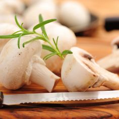 mushrooms on a cutting board with a knife