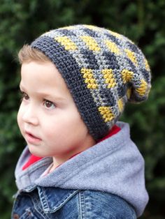 a young boy wearing a gray and yellow knitted hat