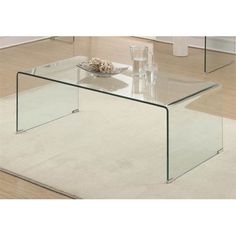 a glass coffee table sitting on top of a white rug